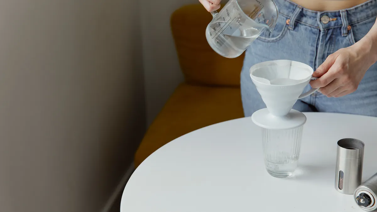 Water being poured through a funnel into a glass