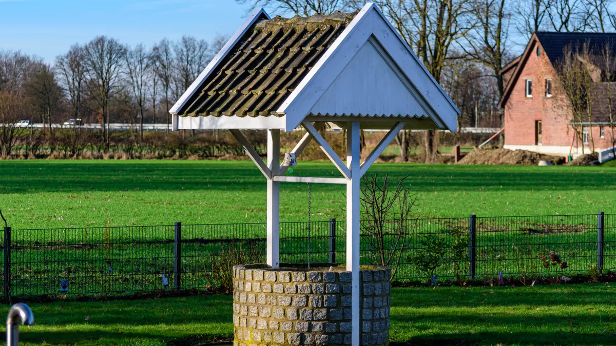 What to Do Before a Water Test if You Use a Well Covered outdoor well in a grassy field